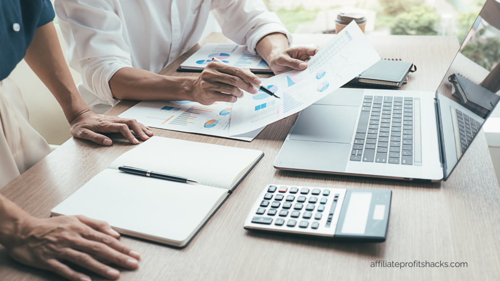 A professional team analyzing data with charts on paper, laptops and calculators on the table, overlaid with the text "Top Project Management Tools For Digital Teams in 2024" and the URL "affiliateprofitshacks.com" at the bottom.